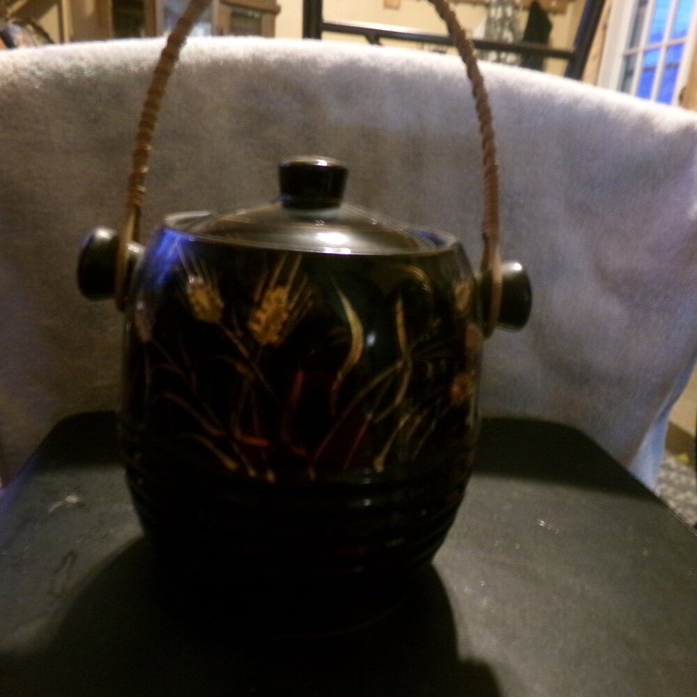 pottery biscuit jar with wicker handle.